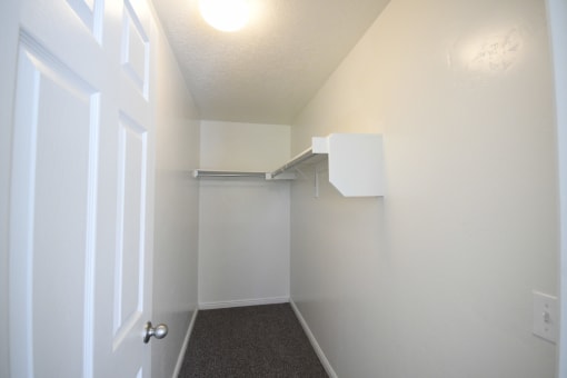 an empty room with a white closet and a door