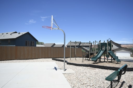 a playground with a basketball hoop and a swing set
