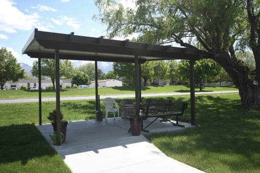 a picnic area with a bench under a gazebo