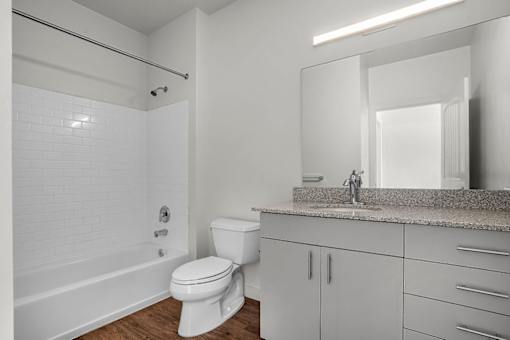 A white bathroom with a toilet, sink, and bathtub.