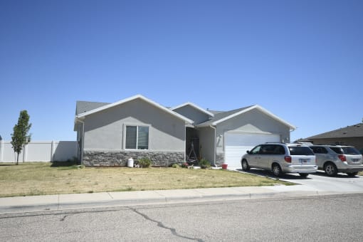 a house with two cars parked in front of it