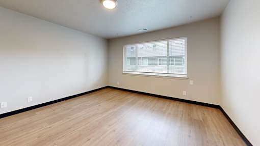 Empty room with wooden floor and a window.
