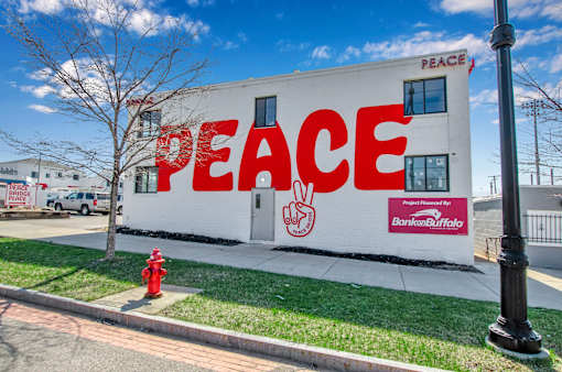 A white building with the word "PEACE" written on it in red.