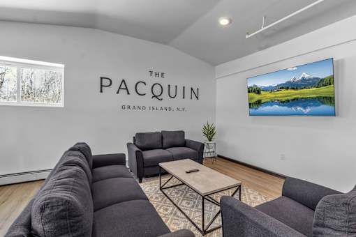 A living room with a large screen TV and a sofa.