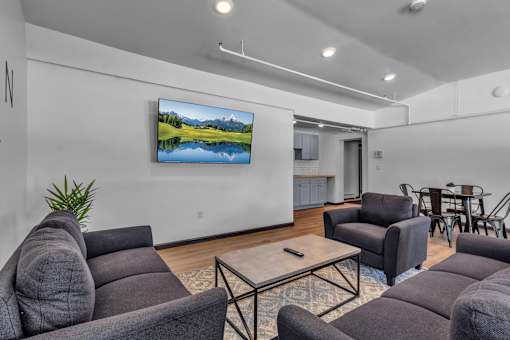 A living room with a large screen TV mounted on the wall.