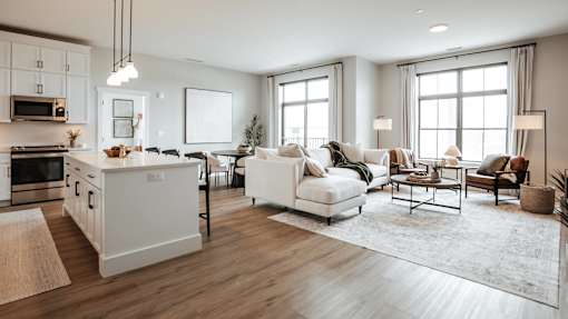 A modern kitchen with white appliances and a dining area with a white sofa and chairs.