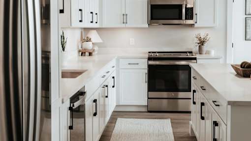A modern kitchen with white cabinets and stainless steel appliances.