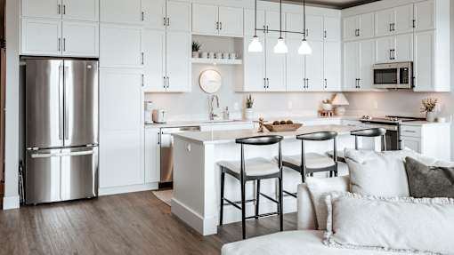 A modern kitchen with a large island and stools.