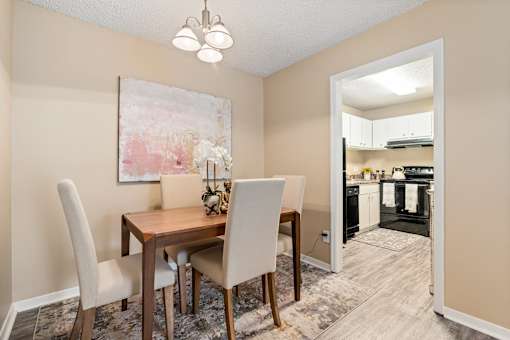 A dining room with a wooden table and chairs.