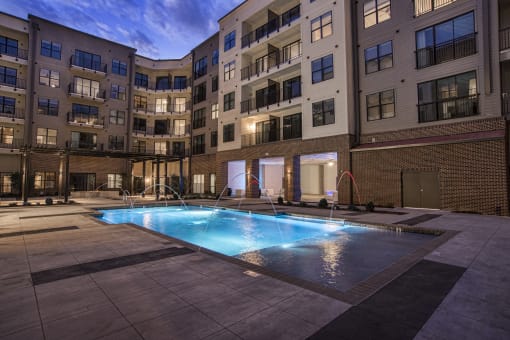an apartment swimming pool in front of an apartment building