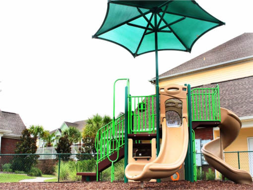 playground being shaded by a blue umbrella