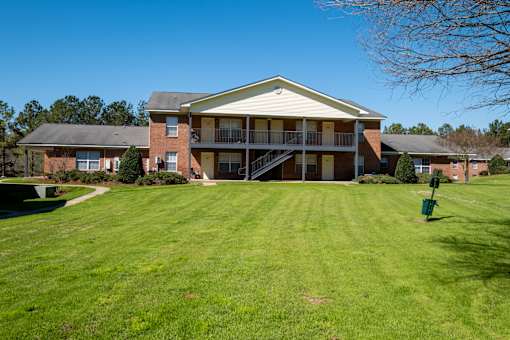 A large house with a green lawn in front.