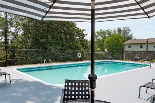 a swimming pool with a black and white umbrella