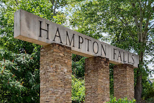 Hampton Falls sign in front of trees.