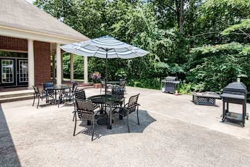 A patio with a table and chairs under an umbrella.