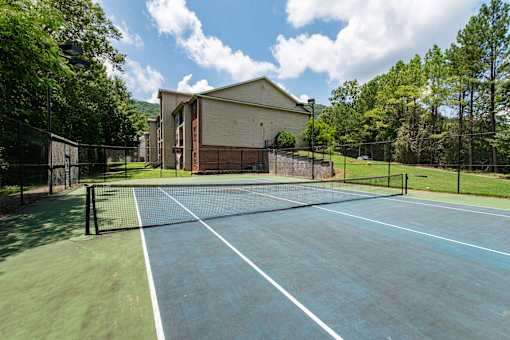 A tennis court with a building in the background.