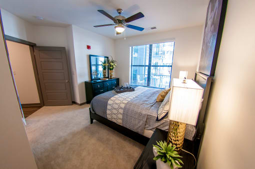 an empty bedroom with a bed and a ceiling fan