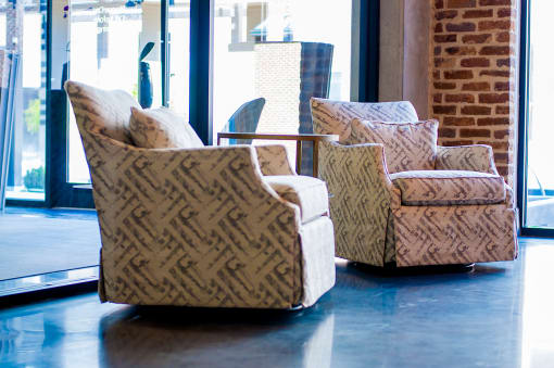two chairs and a table in a room with windows