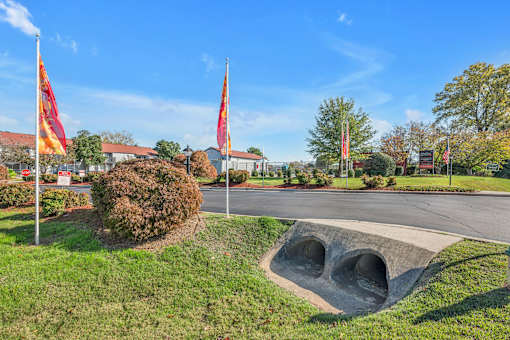 A park with a large concrete structure and flags.