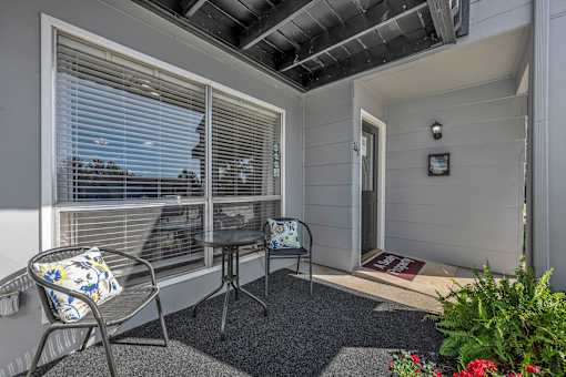 A balcony with a chair and table.