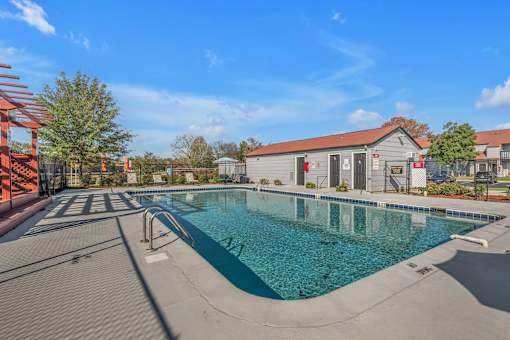 A large outdoor swimming pool with a red structure on the left side.