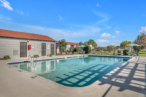 A large outdoor swimming pool with a building in the background.