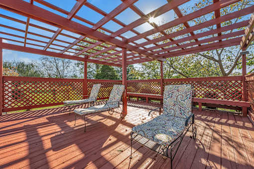 A wooden deck with two chairs and a table.