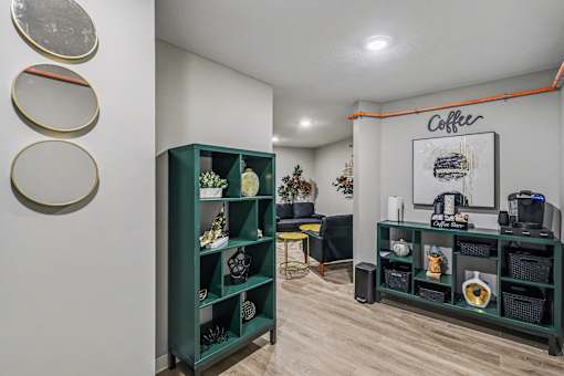 A coffee themed room with a green shelf and a picture of a coffee cup on the wall at Mayfair Apartments, Kansas City