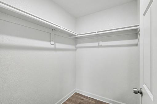 A white closet with a door and shelves at Mayfair Apartments, Kansas City, MO, 64145