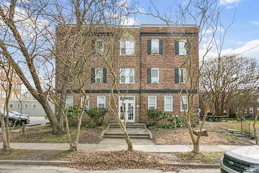 A red brick building with a white door and windows. at Shipyard Shores Apartments, Newport News, VA, 23607
