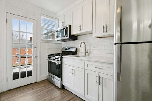 A kitchen with white cabinets and a stainless steel refrigerator at Shipyard Shores Apartments, Virginia, 23607