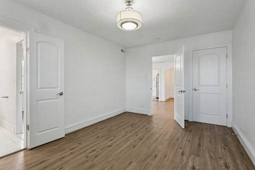 A room with white walls and wooden floors with two doors at Shipyard Shores Apartments, Newport News, Virginia