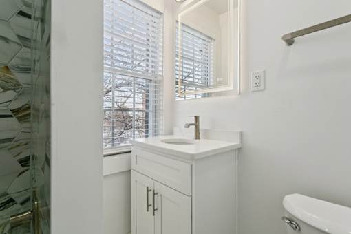 A white bathroom with a sink and a bathtub at Shipyard Shores Apartments, Virginia