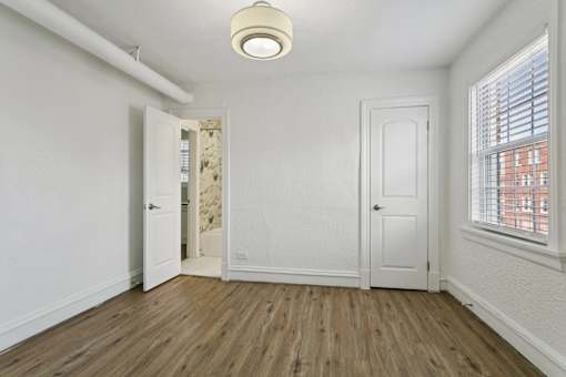 A room with a wooden floor and white walls at Shipyard Shores Apartments, Virginia, 23607