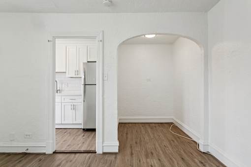 A kitchen with white cabinets and a refrigerator is visible through an open doorway at Shipyard Shores Apartments, Apartments, Newport News, VA