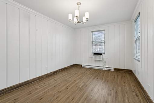 A room with wooden floors and white walls at Shipyard Shores Apartments, Virginia
