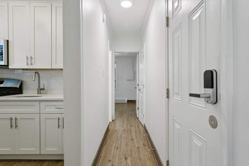 A long white hallway with a white door on the right at Shipyard Shores Apartments, Newport News, VA, 23607