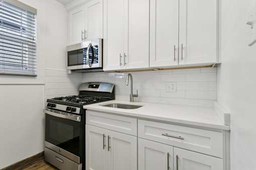 A kitchen with white cabinets and a black stove top oven at Shipyard Shores Apartments, Newport News, 23607