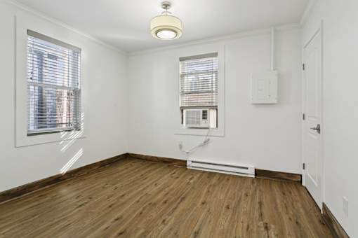 A room with a window and a radiator on the floor at Shipyard Shores Apartments, Newport News, Virginia