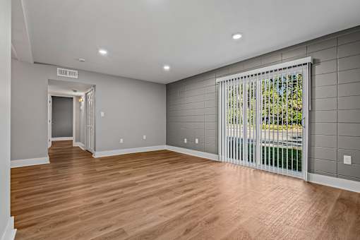 A room with wooden floors and a sliding glass door. at Serenity Place Central, Florida, 32304