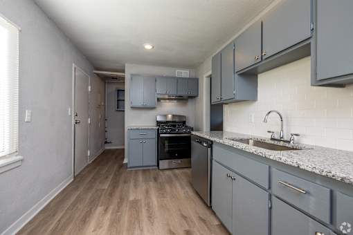 A kitchen with a sink, stove, and cabinets. at Blacklark Apartments, Kansas