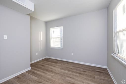 A room with wooden flooring and a window with blinds. at Blacklark Apartments, Kansas City, 66101