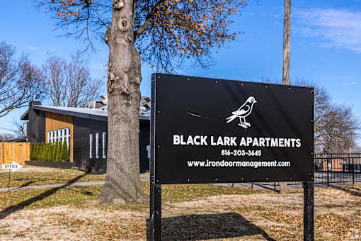 A sign for Black Lark Apartments stands in front of a building. at Blacklark Apartments, Kansas City