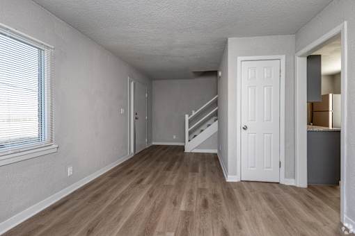 A room with a white door and a staircase leading to another room. at Blacklark Apartments, Kansas City, 66101