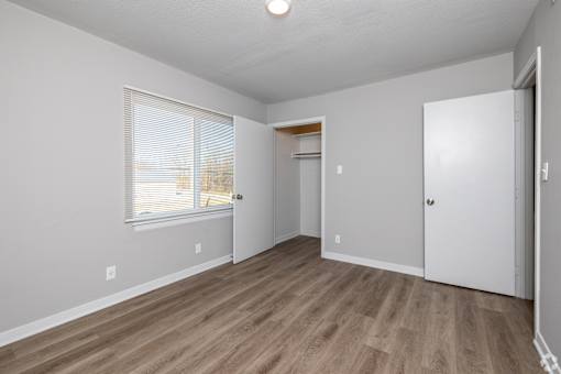 A room with a wooden floor and white walls. at Blacklark Apartments, Kansas City
