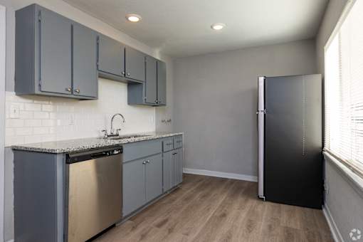 A kitchen with a black refrigerator and a stainless steel dishwasher. at Blacklark Apartments, Apartments, Kansas City, KS