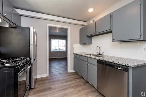 A kitchen with a stove, dishwasher, and cabinets. at Blacklark Apartments, Kansas