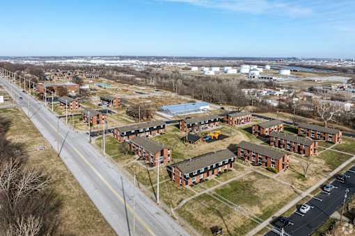 A road runs through a housing development with apartment buildings on either side. at Blacklark Apartments, Apartments, Kansas City, KS