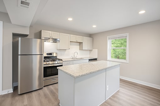 A kitchen with a stainless steel refrigerator and a granite countertop.at Palisades Apartments, Kansas City Missouri