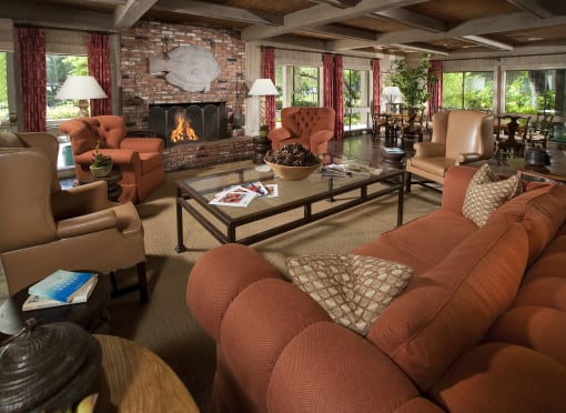 a clubhouse living room with couches and chairs and a fireplace